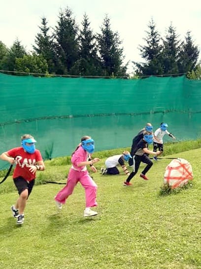 młodzież na koloni szalej podczas atrakcji walki na łuki w wiosce indiańskiej w starym waliszowie, czekając na urodziny